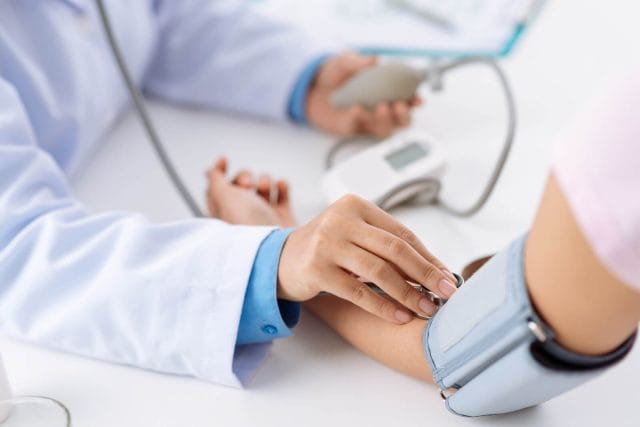 A doctor takes blood pressure reading.