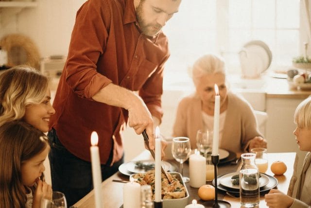 A multi-generation family sits around a dinner table.