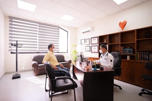a doctor and patient sit in a doctor's office.